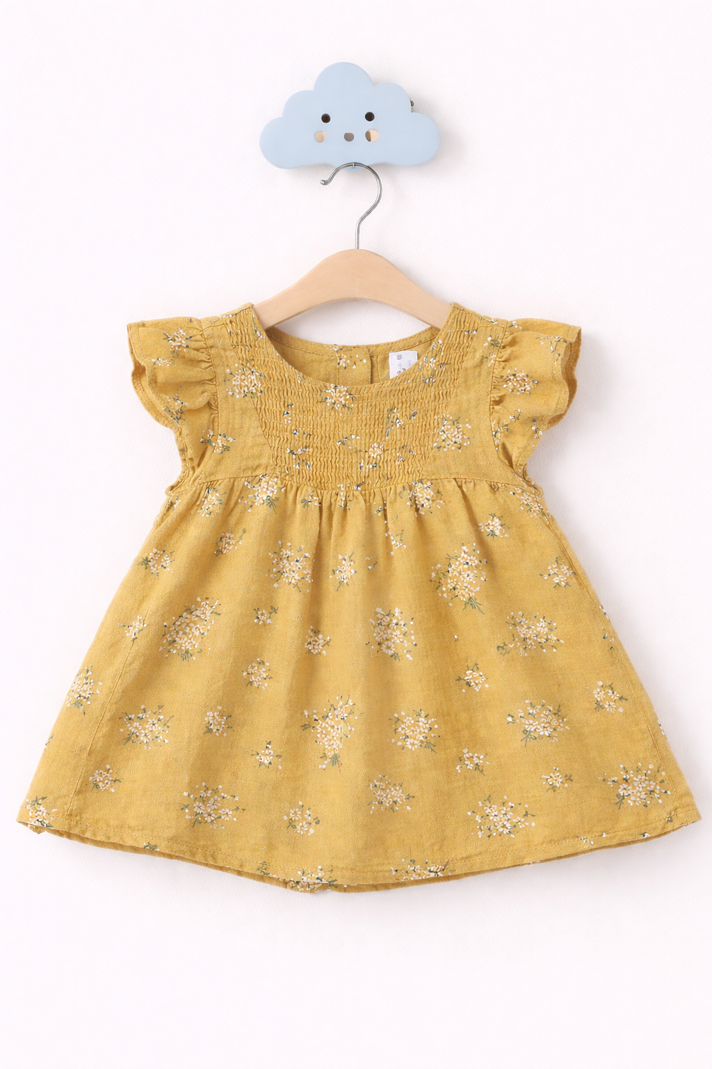 Mustard yellow baby dress on hook