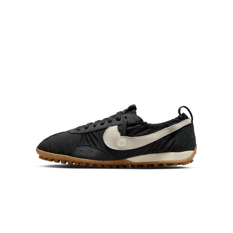 Side profile of Jacquemus x Nike Moon Shoe SP Off-Noir sneaker HV8547-001, featuring black ruched nylon, a leather Swoosh, and a gum rubber waffle sole. Available in Singapore and Malaysia.