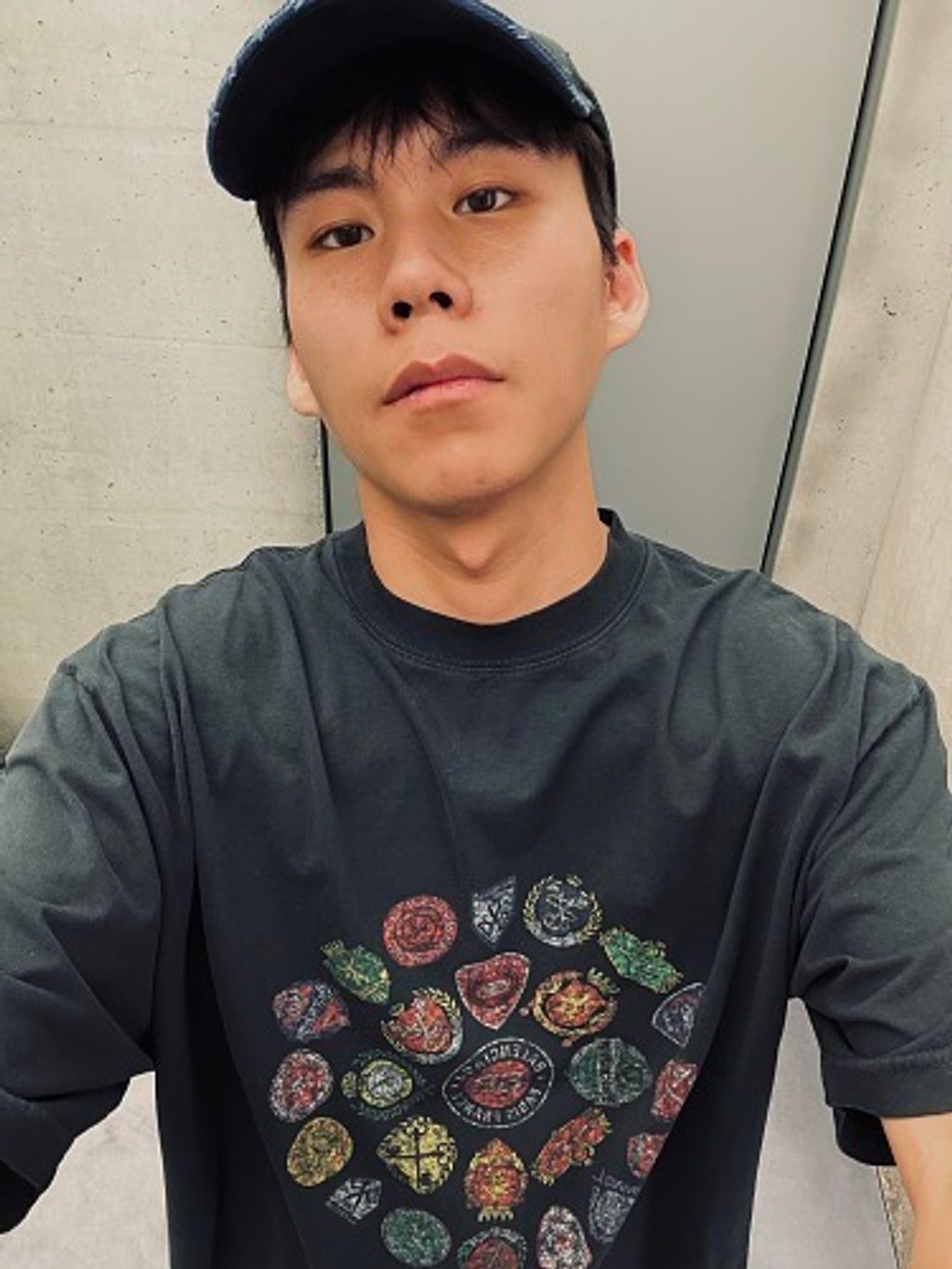 Front and back view of the Balenciaga Vintage Badge Print T-Shirt in washed black, featuring a circular vintage badge graphic on the front, a gothic logo on the back, and a relaxed oversized fit. Available in Singapore and Malaysia.