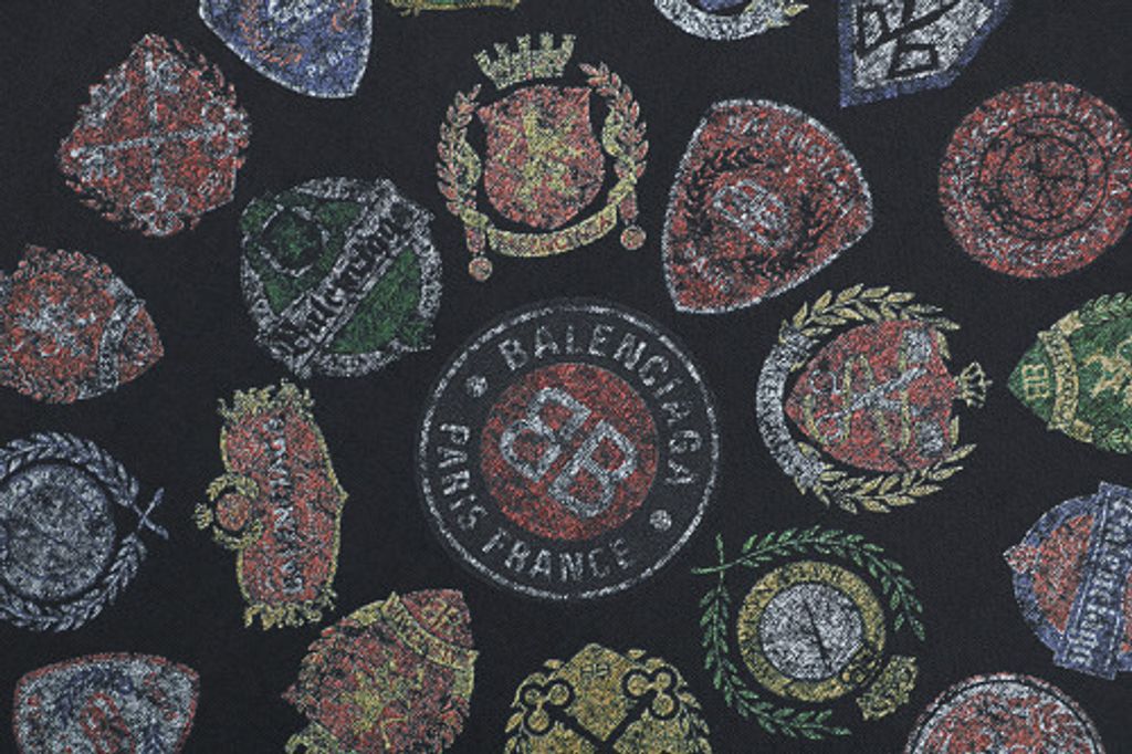 Front and back view of the Balenciaga Vintage Badge Print T-Shirt in washed black, featuring a circular vintage badge graphic on the front, a gothic logo on the back, and a relaxed oversized fit. Available in Singapore and Malaysia.