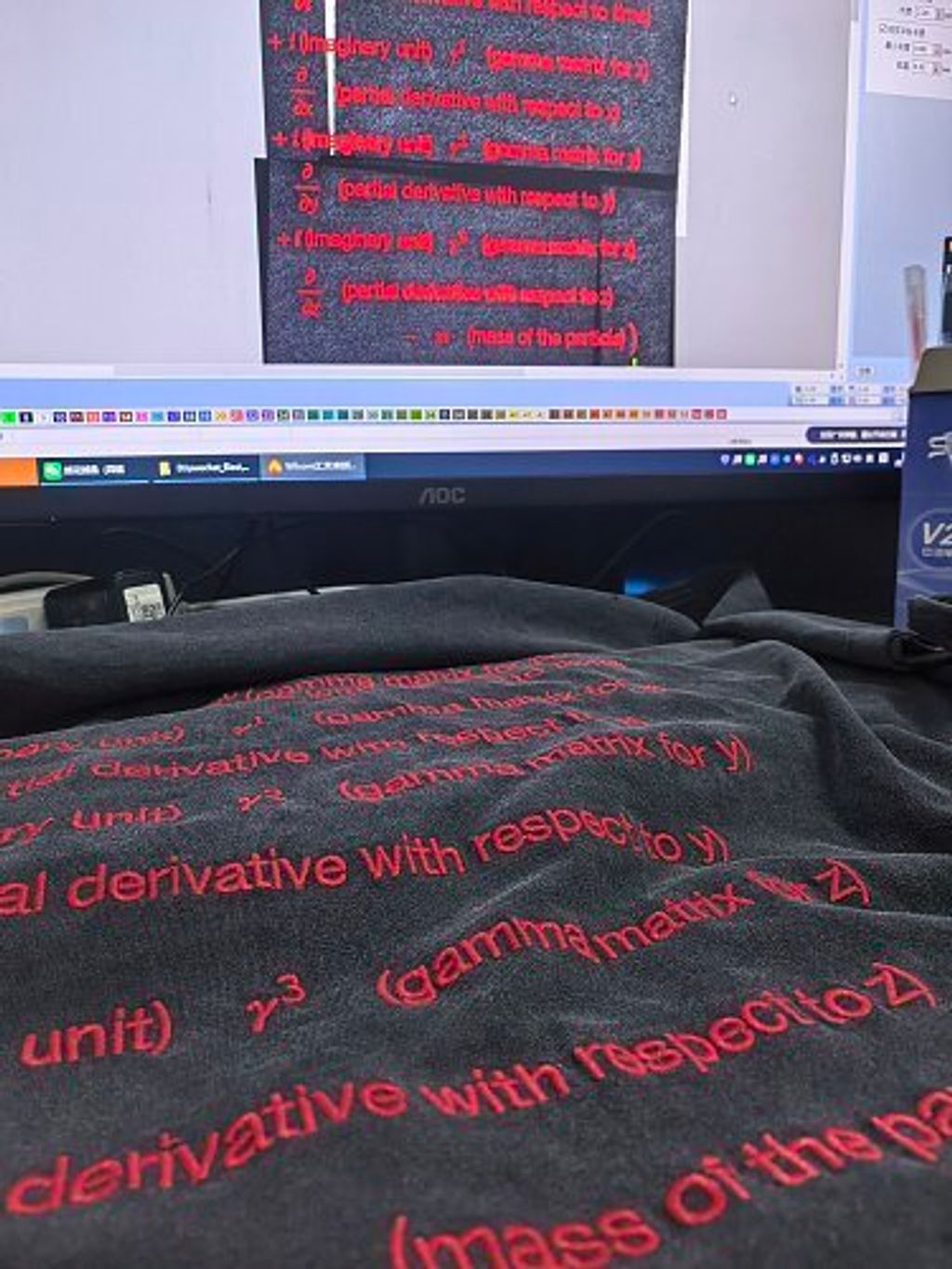 Front and back view of the Balenciaga Dirac Equation embroidered t-shirt in washed black, featuring red physics equation embroidery on the chest, explanatory text on the back, and hand-distressed collar and cuffs. Available in Singapore and Malaysia.