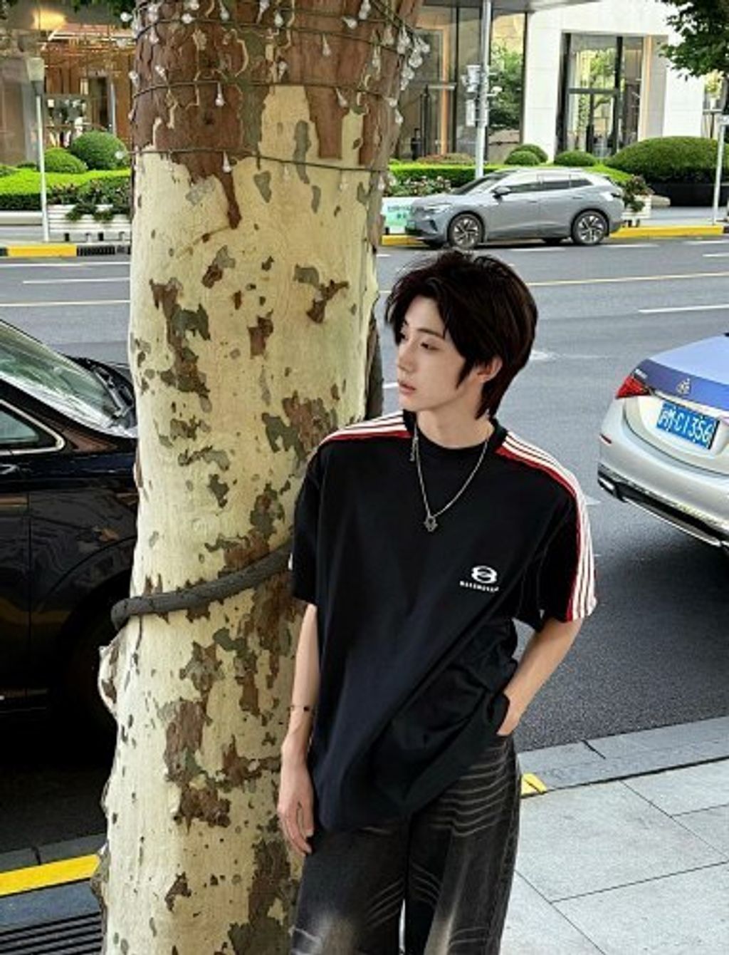 Front and back view of the Balenciaga Double Ring stripe t-shirt in black, featuring red and white racing stripes on the shoulders, a double-ring logo on the chest, and a relaxed oversized fit. Available in Singapore and Malaysia.