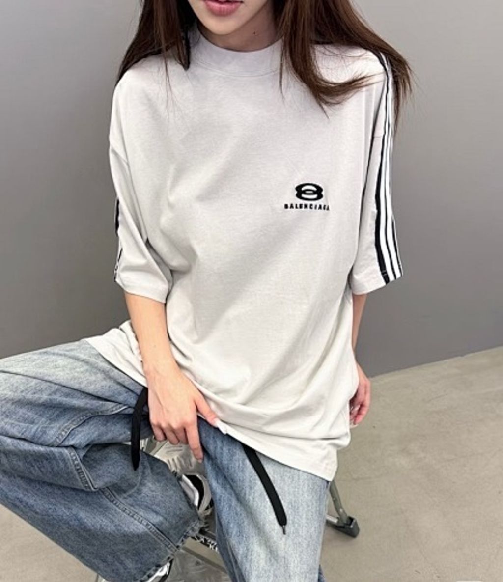 Front and back view of the Balenciaga Double Ring stripe t-shirt in off-white, featuring black and white racing stripes on the shoulders, a double-ring logo on the chest, and a relaxed oversized fit. Available in Singapore and Malaysia.