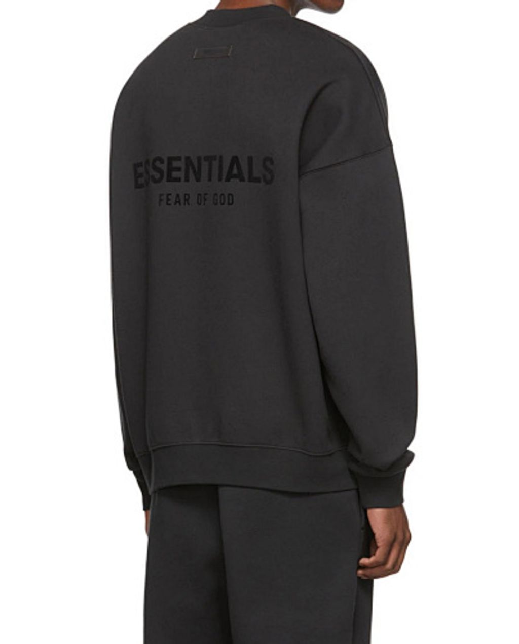 Front and back view of the black Fear of God Essentials crewneck sweatshirt, featuring a tonal black flocked logo on the chest and back, with a relaxed drop-shoulder fit. Available in Singapore and Malaysia.