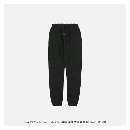 Front and back view of the black Fear of God Essentials sweatpants, featuring a tonal black flocked logo on the left leg, elongated cotton drawstrings, and a relaxed tapered fit. Available in Singapore and Malaysia.