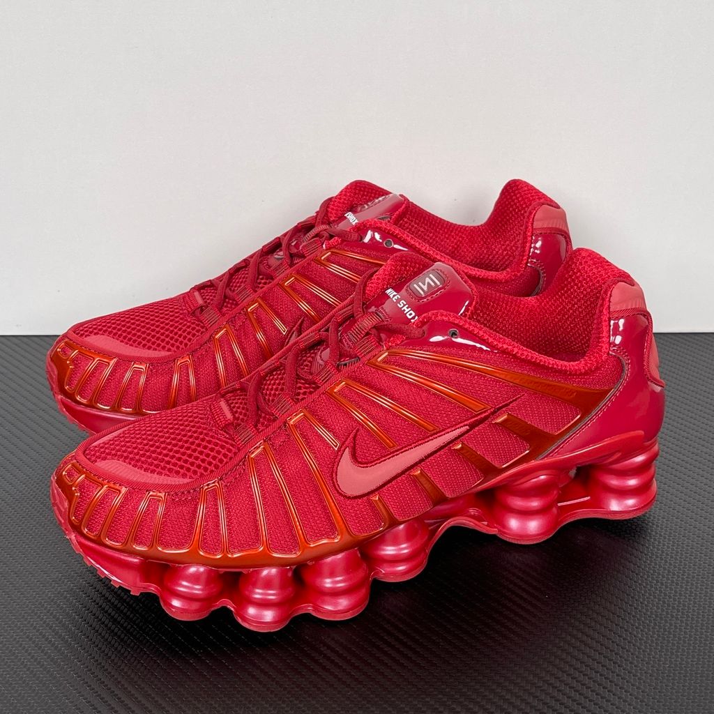 Side profile of the Nike Shox TL sneaker IB1087-600 in Gym Red, featuring a breathable red mesh upper, structural white TPU cage overlays, and full-length visible Shox column cushioning. Available in Singapore and Malaysia..jpg