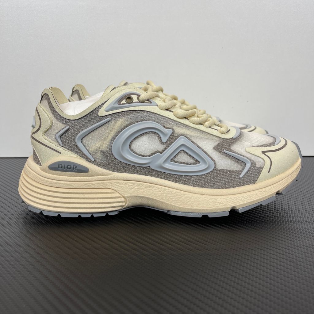 Side profile of the 26SS Dior B30 sneaker in orange and grey, featuring breathable technical mesh, reflective rubber CD30 signatures, and a sculpted lightweight rubber and EVA outsole. Available in Singapore and Malaysia.