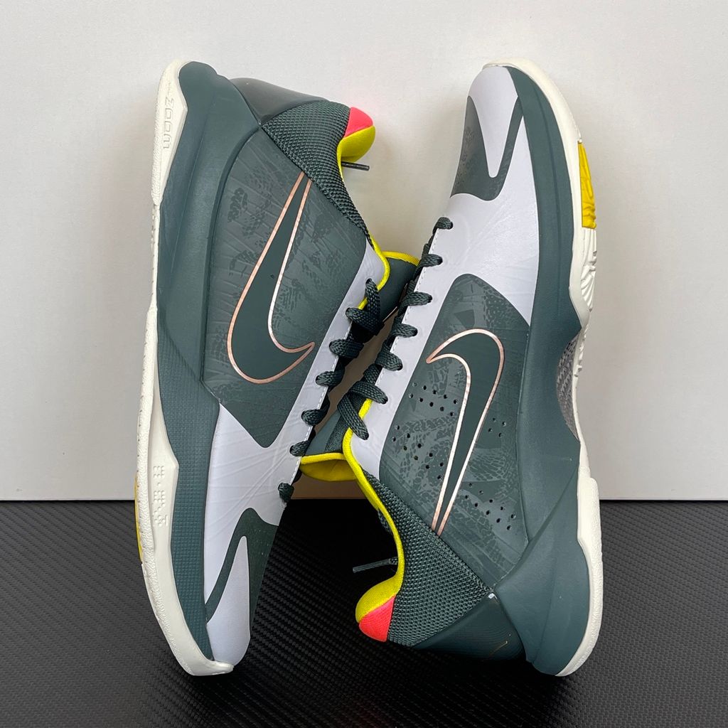 Side profile of the Nike Kobe 5 Protro sneaker CD4991-300 in the EYBL Girls colorway, featuring a dark forest green synthetic upper, a metallic red bronze Swoosh, and the EYBL logo on the tongue. Available in Singapore and Malaysia.
