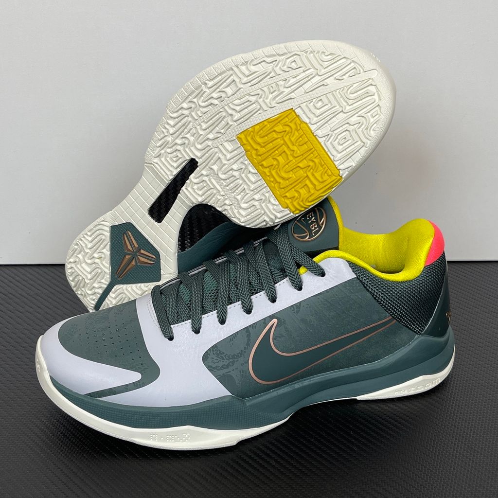 Side profile of the Nike Kobe 5 Protro sneaker CD4991-300 in the EYBL Girls colorway, featuring a dark forest green synthetic upper, a metallic red bronze Swoosh, and the EYBL logo on the tongue. Available in Singapore and Malaysia.