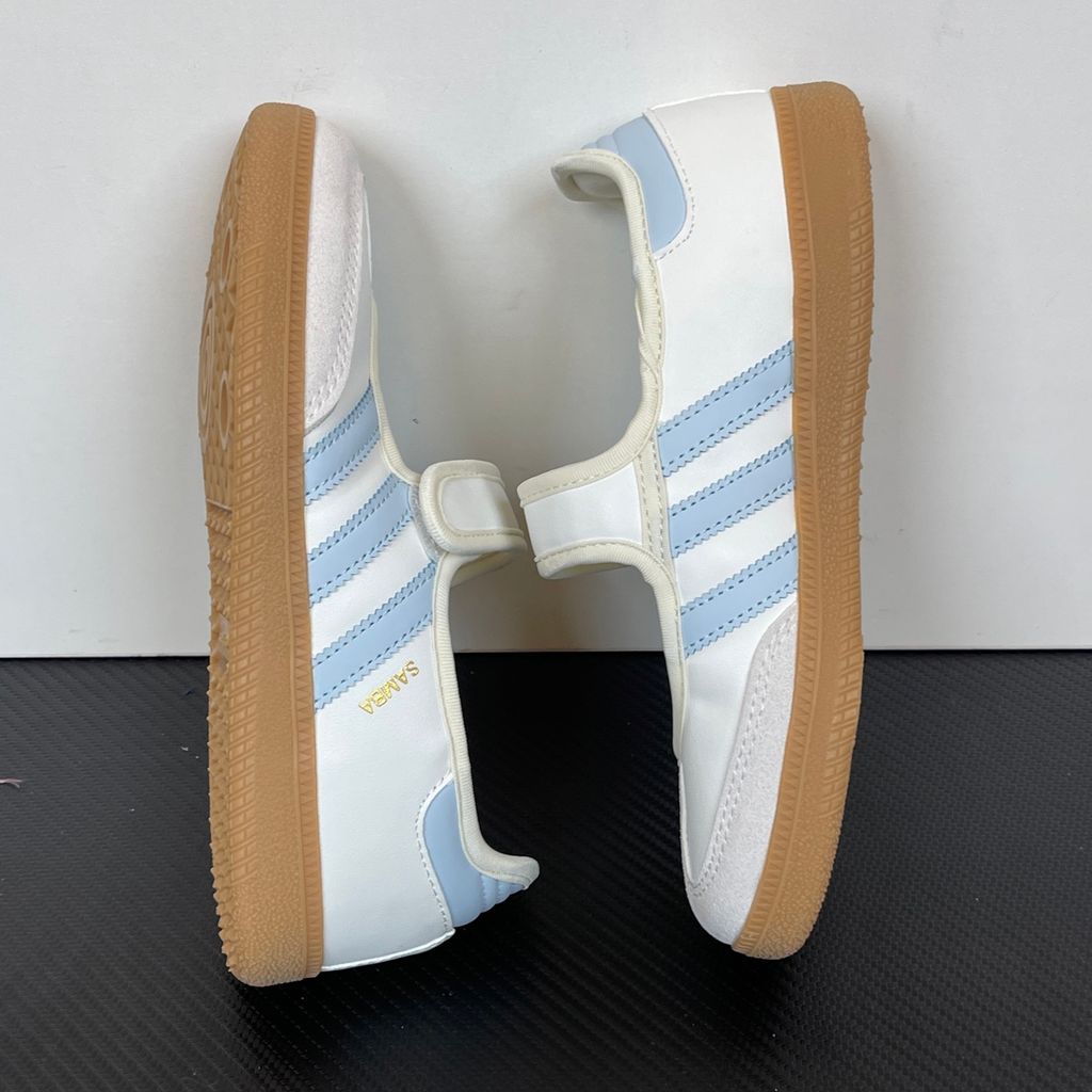 Side profile of the adidas Samba Jane White Blue Gum Women's sneaker JR7339, featuring a clean white leather upper, vibrant blue serrated 3-Stripes, an adjustable midfoot strap, and a classic gum rubber outsole. Available in Singapore and Malaysia..jpg