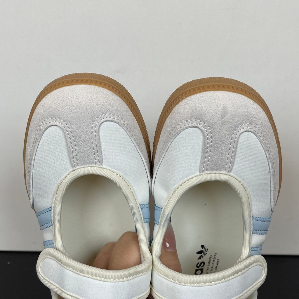 Side profile of the adidas Samba Jane White Blue Gum Women's sneaker JR7339, featuring a clean white leather upper, vibrant blue serrated 3-Stripes, an adjustable midfoot strap, and a classic gum rubber outsole. Available in Singapore and Malaysia..jpg
