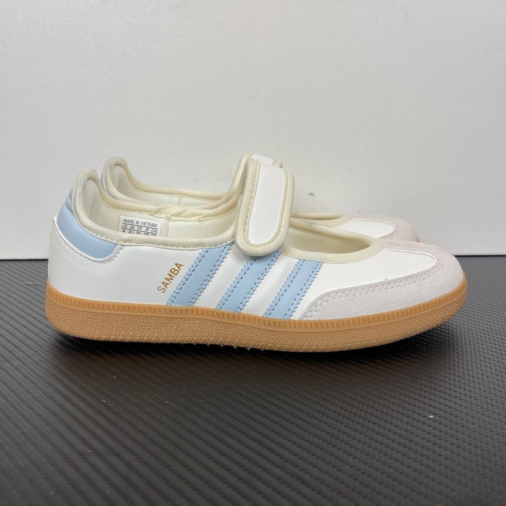 Side profile of the adidas Samba Jane White Blue Gum Women's sneaker JR7339, featuring a clean white leather upper, vibrant blue serrated 3-Stripes, an adjustable midfoot strap, and a classic gum rubber outsole. Available in Singapore and Malaysia..jpg