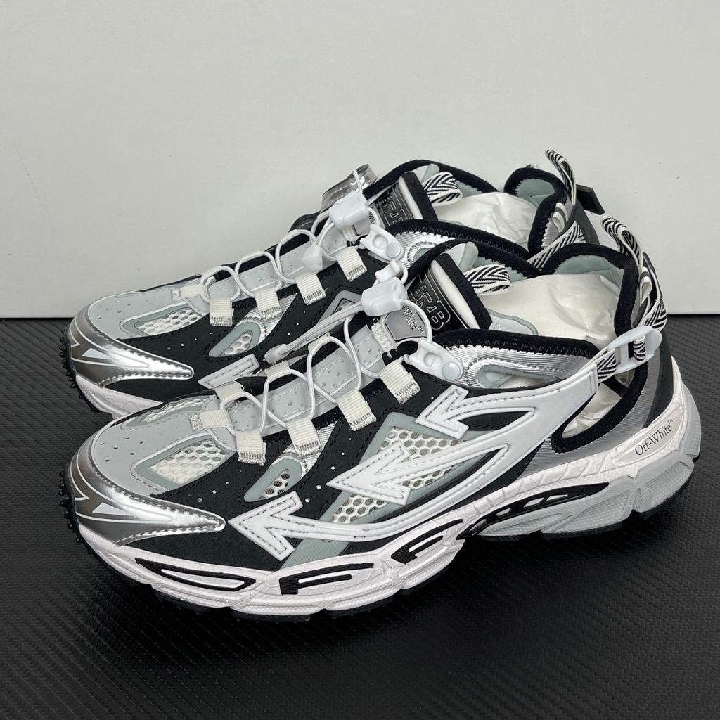 Authentic Off-White Be Right Back (BRB) sneaker in metallic silver, white, and black, featuring a technical mesh base and the signature Off-White Arrow logo on the lateral side, SKU OMIA29SS26FAB0017210.