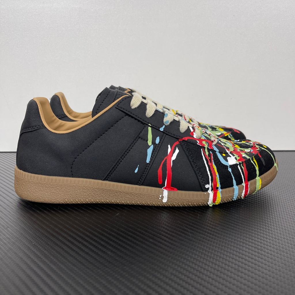 Maison Margiela Replica low-top sneaker in matte black calfskin leather featuring an avant-garde multicolor hand-splattered paint drop design across the toe box and a classic gum sole, style code S58WS0109P1895T1016..jpg