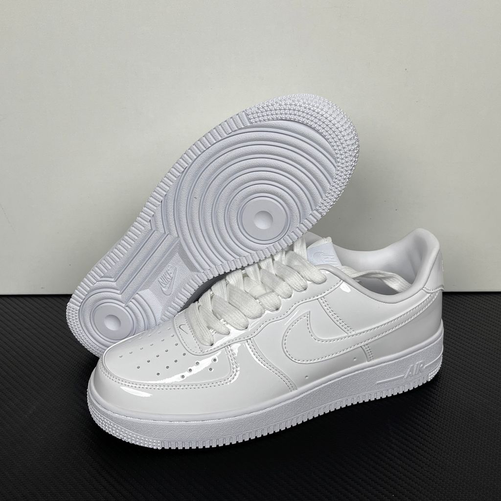 Nike Air Force 1 Low '07 Premium sneaker in high-gloss White Patent leather, featuring a tonal white Swoosh and classic chunky rubber sole, SKU IV2857-100.