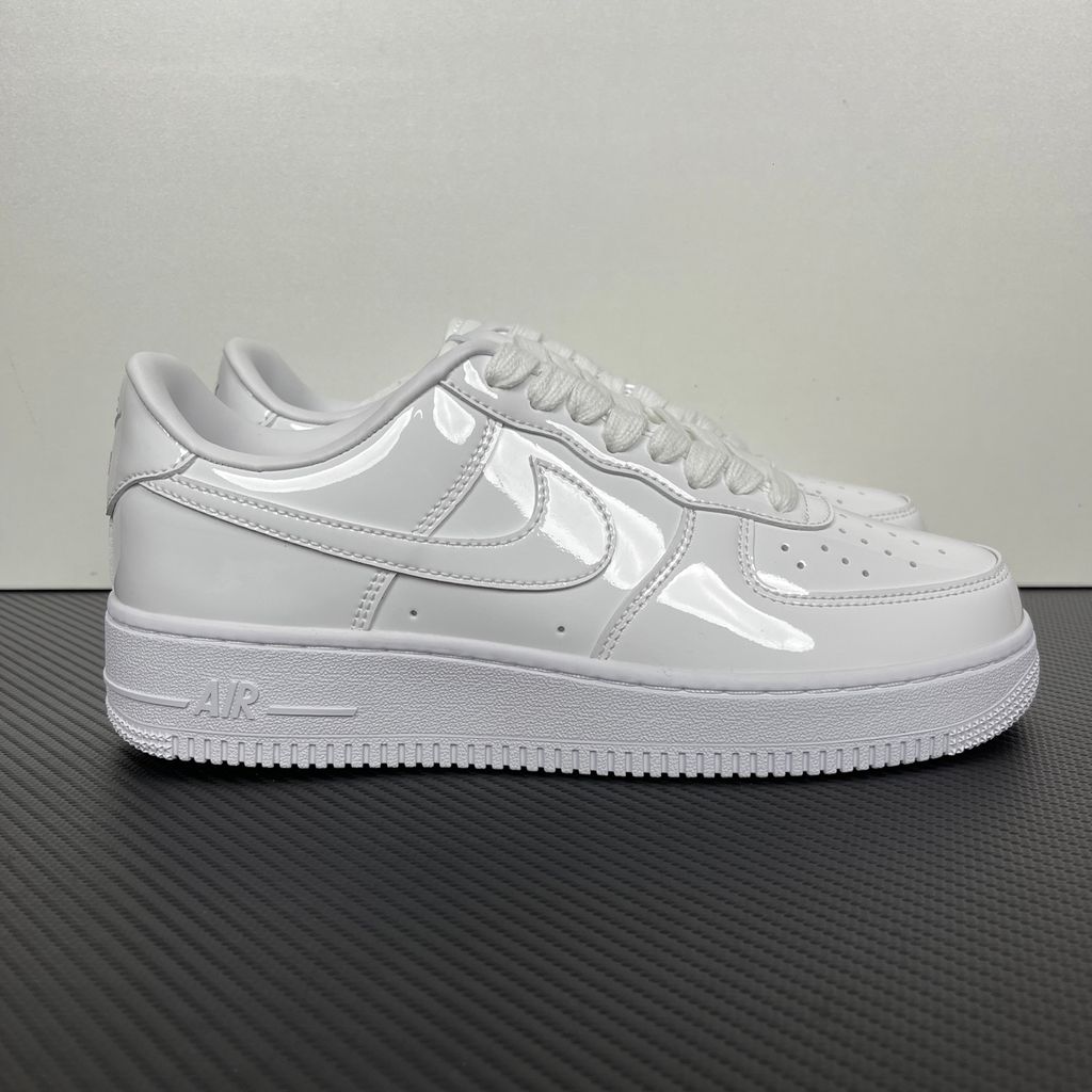 Nike Air Force 1 Low '07 Premium sneaker in high-gloss White Patent leather, featuring a tonal white Swoosh and classic chunky rubber sole, SKU IV2857-100.