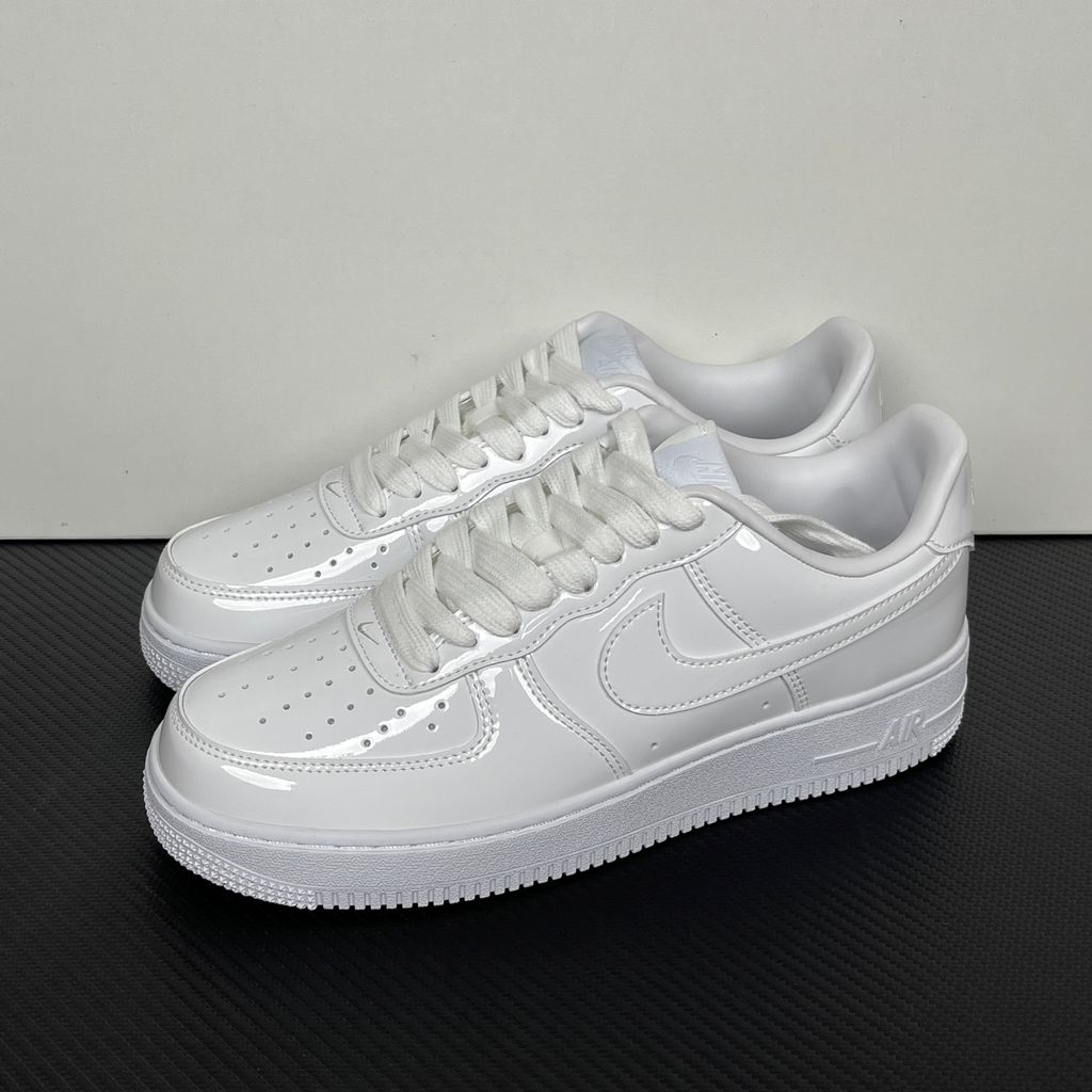 Nike Air Force 1 Low '07 Premium sneaker in high-gloss White Patent leather, featuring a tonal white Swoosh and classic chunky rubber sole, SKU IV2857-100.