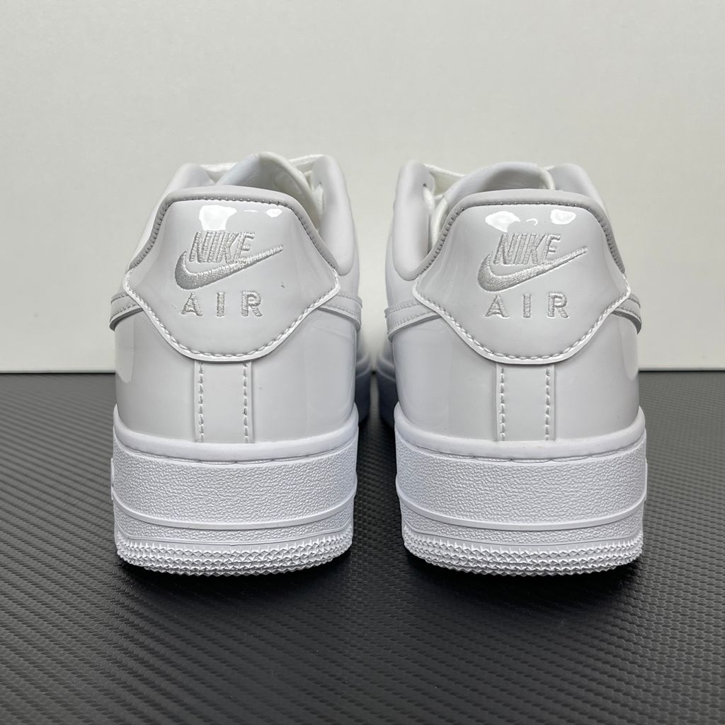 Nike Air Force 1 Low '07 Premium sneaker in high-gloss White Patent leather, featuring a tonal white Swoosh and classic chunky rubber sole, SKU IV2857-100.