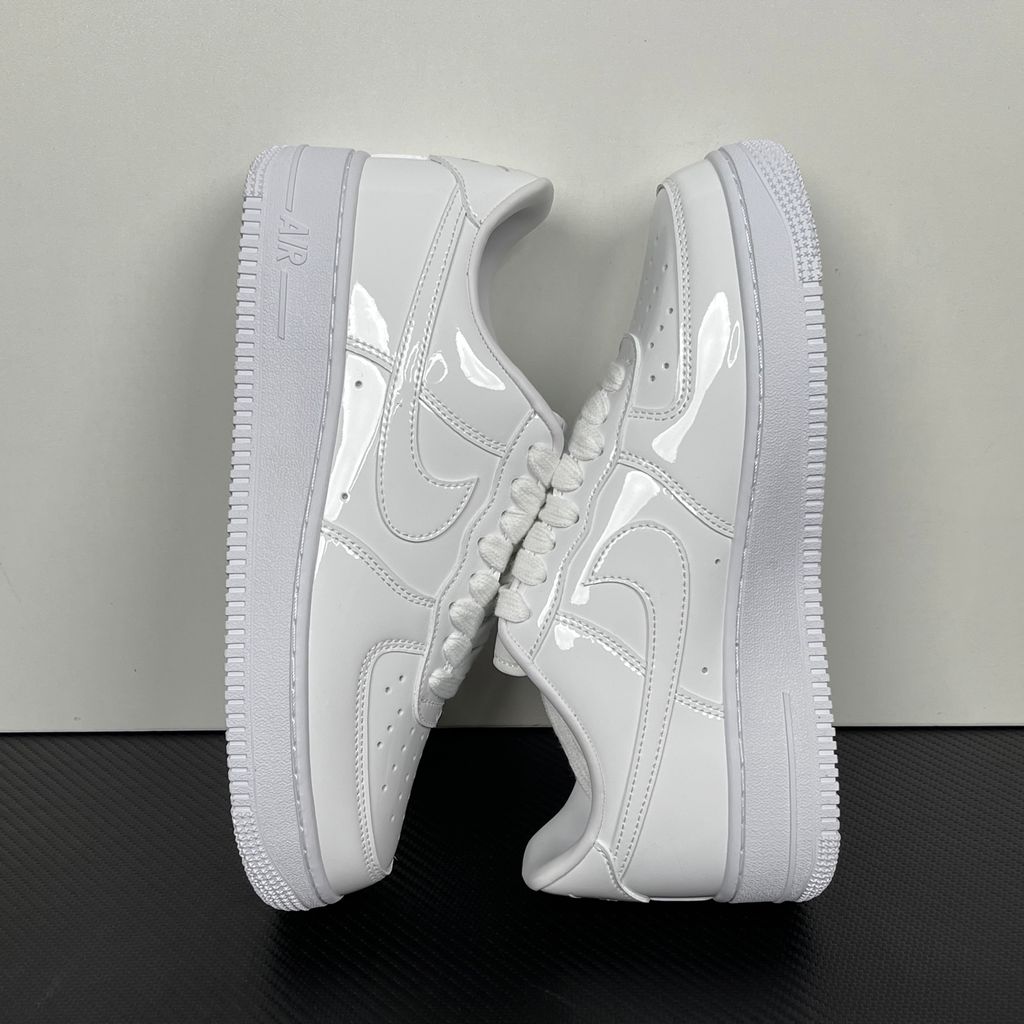 Nike Air Force 1 Low '07 Premium sneaker in high-gloss White Patent leather, featuring a tonal white Swoosh and classic chunky rubber sole, SKU IV2857-100.