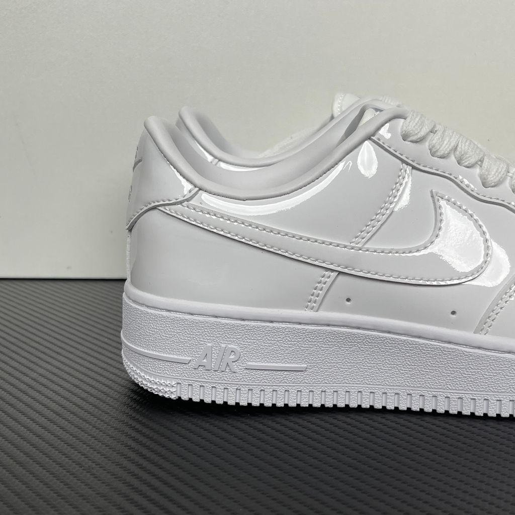 Nike Air Force 1 Low '07 Premium sneaker in high-gloss White Patent leather, featuring a tonal white Swoosh and classic chunky rubber sole, SKU IV2857-100.