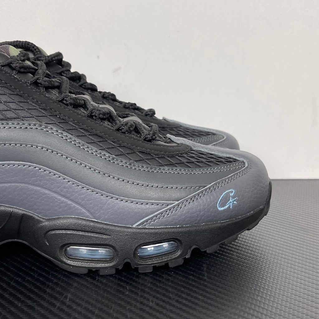 Limited edition Nike Air Max 95 SP x Corteiz (CRTZ RTW) sneaker in Black and Aegean Storm, featuring premium leather overlays, netted mesh, and crisp blue visible Air units, SKU FB2709-002.