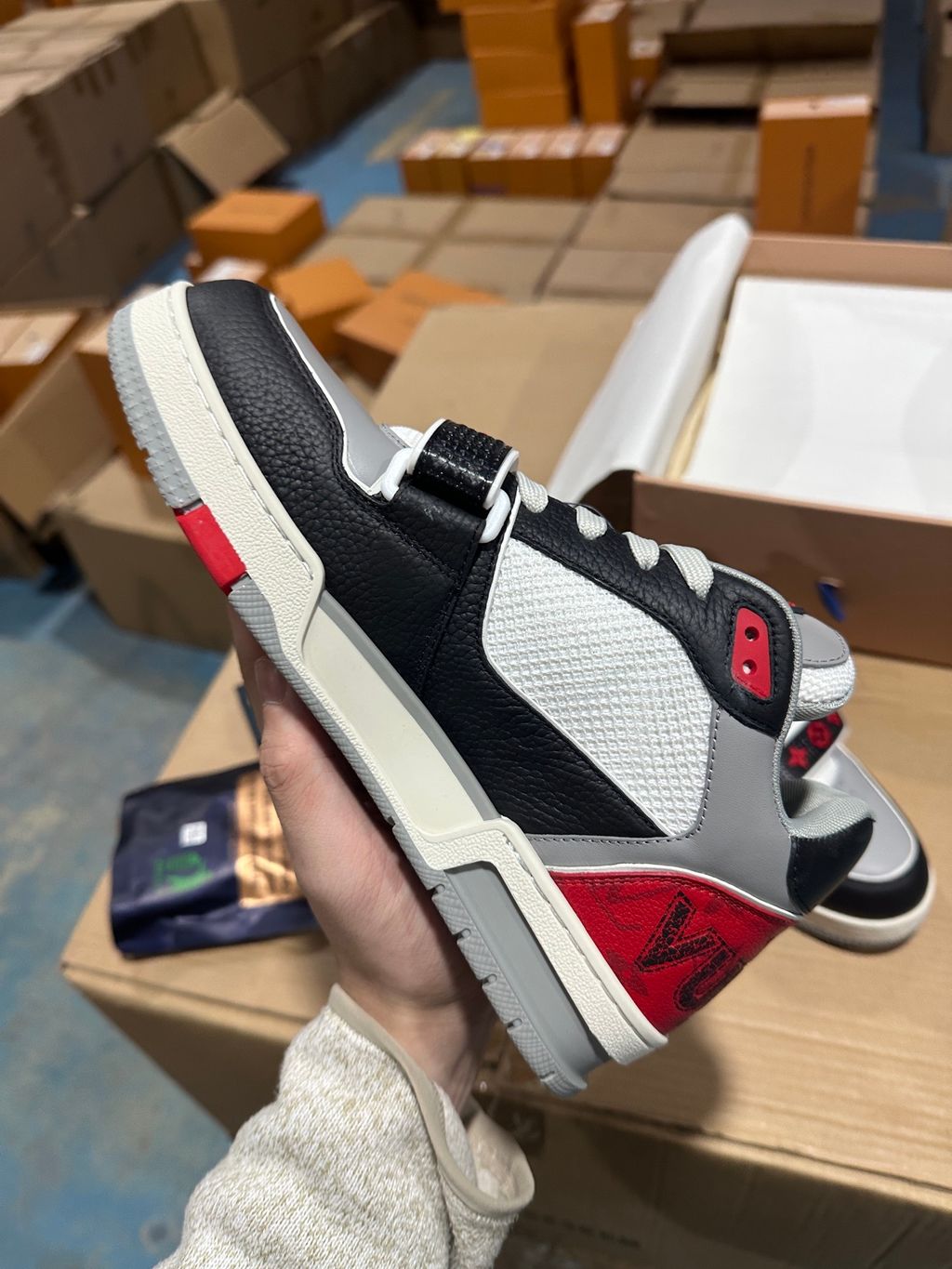 Louis Vuitton LV Trainer Mid sneaker in black, grey, and red premium calf leather, featuring a branded velcro strap across the forefoot, SKU 1AC4ZU.