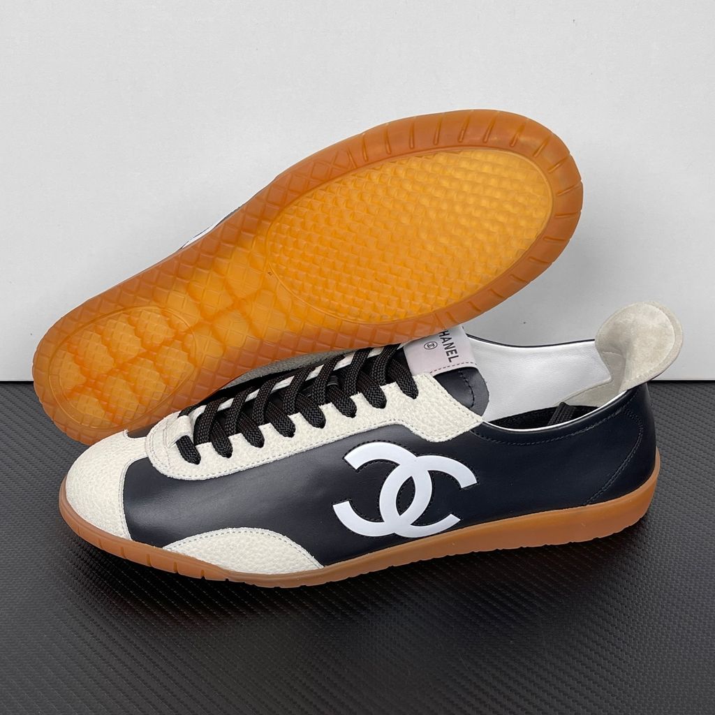 CHANEL 26P low-top sneaker in black smooth calfskin and light grey suede overlays, featuring a prominent white interlocking CC logo on the side panel and a vintage gum rubber sole, SKU G47126.