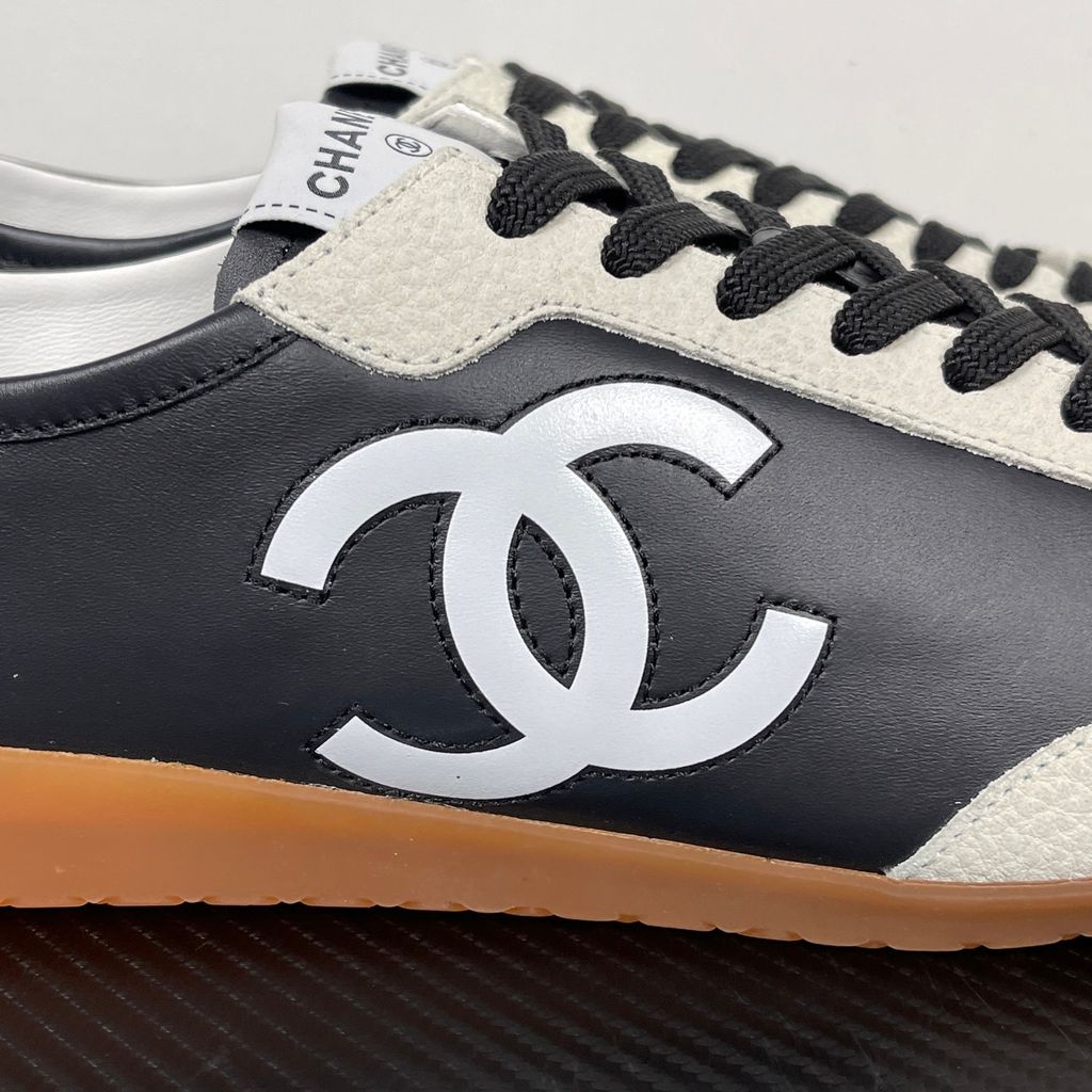 CHANEL 26P low-top sneaker in black smooth calfskin and light grey suede overlays, featuring a prominent white interlocking CC logo on the side panel and a vintage gum rubber sole, SKU G47126.