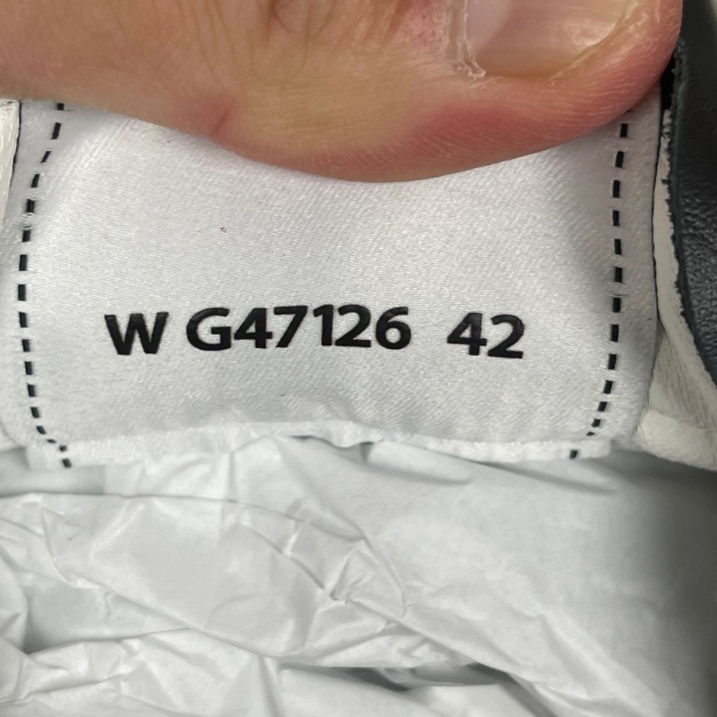 CHANEL 26P low-top sneaker in black smooth calfskin and light grey suede overlays, featuring a prominent white interlocking CC logo on the side panel and a vintage gum rubber sole, SKU G47126.