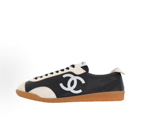 CHANEL 26P low-top sneaker in black smooth calfskin and light grey suede overlays, featuring a prominent white interlocking CC logo on the side panel and a vintage gum rubber sole, SKU G47126..pic