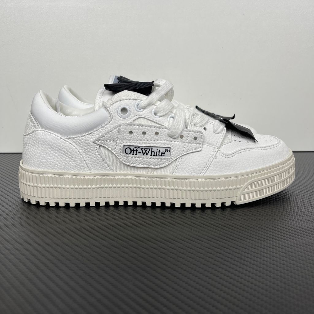 Off-White 3.0 Off Court Low sneaker in pure white tumbled calfskin leather, featuring black industrial label detailing, classic Off-White side typography, and a thick ribbed rubber midsole, SKU 0010110.