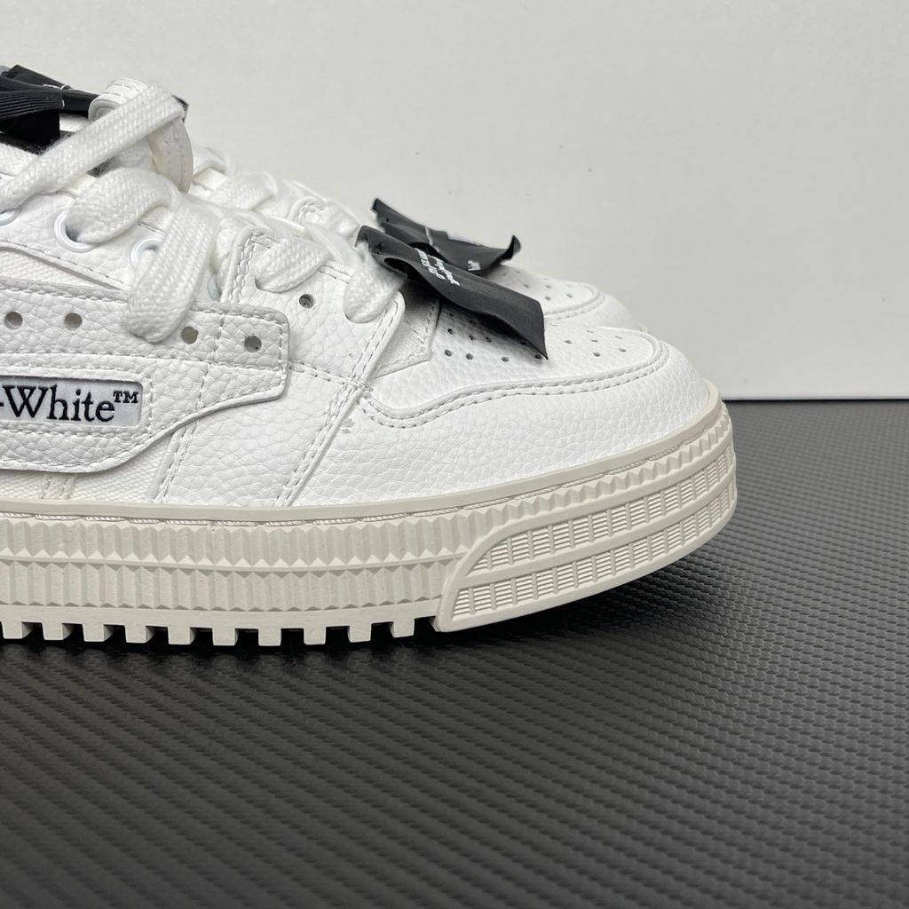 Off-White 3.0 Off Court Low sneaker in pure white tumbled calfskin leather, featuring black industrial label detailing, classic Off-White side typography, and a thick ribbed rubber midsole, SKU 0010110.