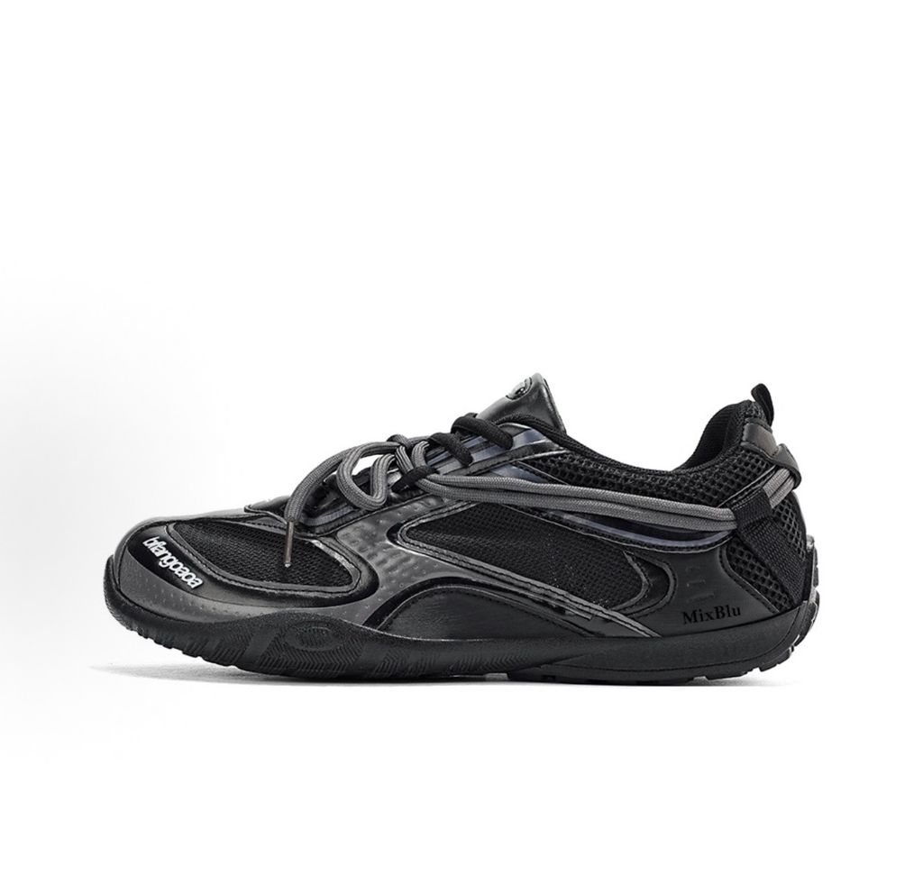 Balenciaga Radar low-profile sneaker in all black, featuring breathable mesh panels, sleek synthetic overlays, a thin driving-style sole, and the classic white Balenciaga logo on the toe edge, SKU 865704WSTE1011.