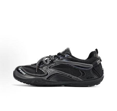 Balenciaga Radar low-profile sneaker in all black, featuring breathable mesh panels, sleek synthetic overlays, a thin driving-style sole, and the classic white Balenciaga logo on the toe edge, SKU 865704WSTE1011.