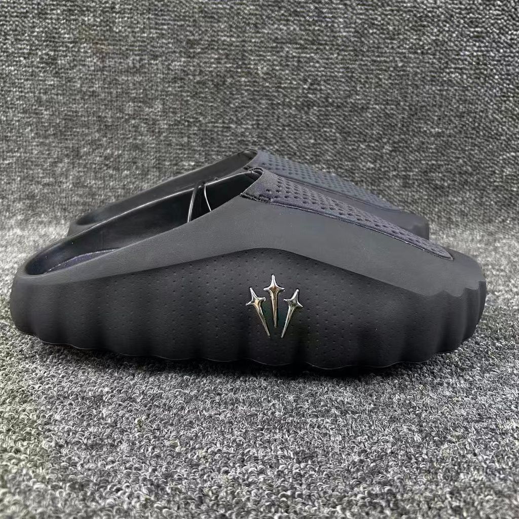 Nike x NOCTA Mind 001 premium lifestyle slide in all black, featuring a tactical, tech-wear inspired molded upper and subtle NOCTA branding.
