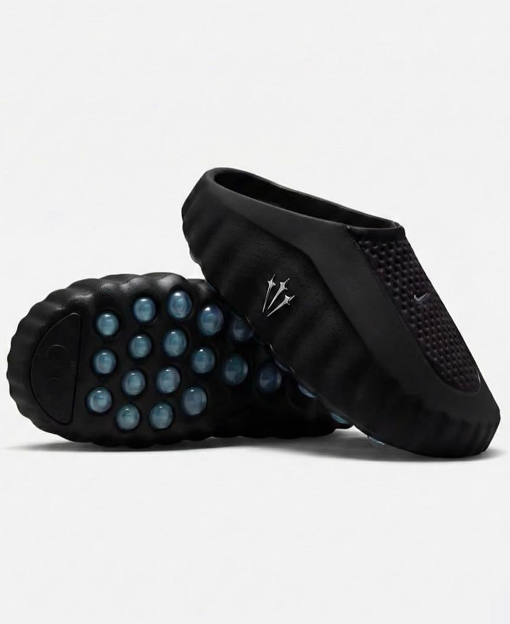 Nike x NOCTA Mind 001 premium lifestyle slide in all black, featuring a tactical, tech-wear inspired molded upper and subtle NOCTA branding.