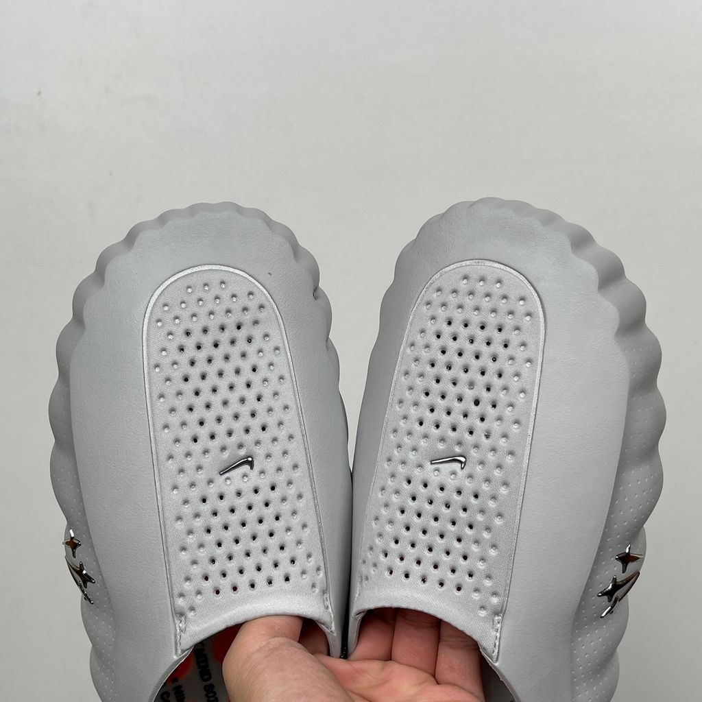 Nike x NOCTA Mind 001 premium lifestyle slide in a monochromatic light grey, featuring a tactical, tech-wear inspired molded upper and subtle NOCTA branding.