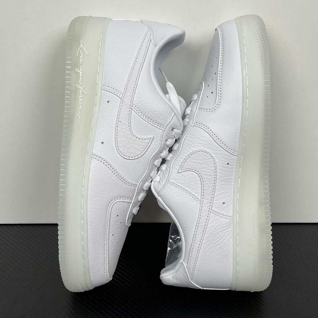 Nike Air Force 1 Low x Drake NOCTA "Certified Lover Boy" sneaker in pristine white premium leather with subtle Cobalt Tint accents and custom NOCTA heel branding, SKU CZ8065-101.