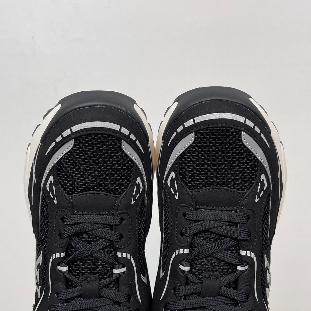 Louis Vuitton Tatic Runner lifestyle sneaker in black mesh and synthetic materials, featuring white and grey accents, prominent LV side logo, and "VUITTON" midsole embossing, SKU 1AKC07.