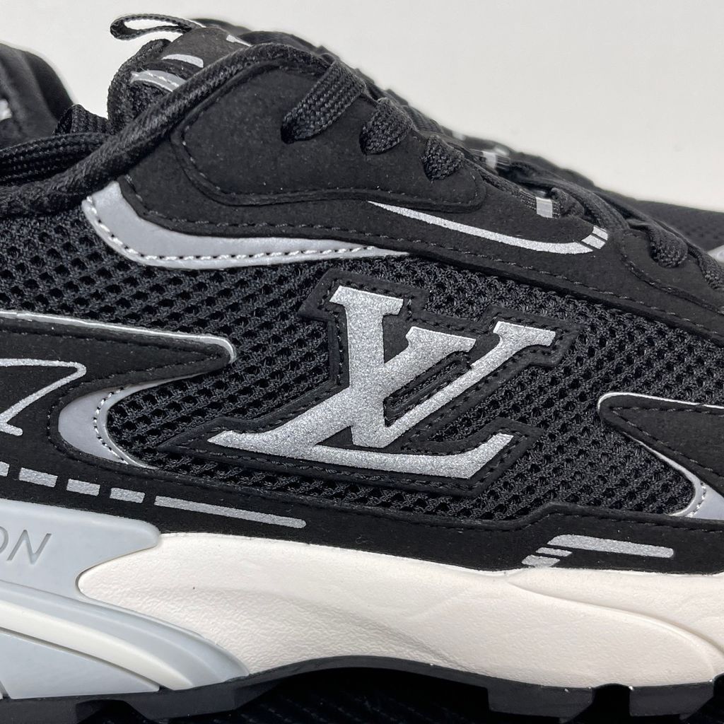 Louis Vuitton Tatic Runner lifestyle sneaker in black mesh and synthetic materials, featuring white and grey accents, prominent LV side logo, and "VUITTON" midsole embossing, SKU 1AKC07.
