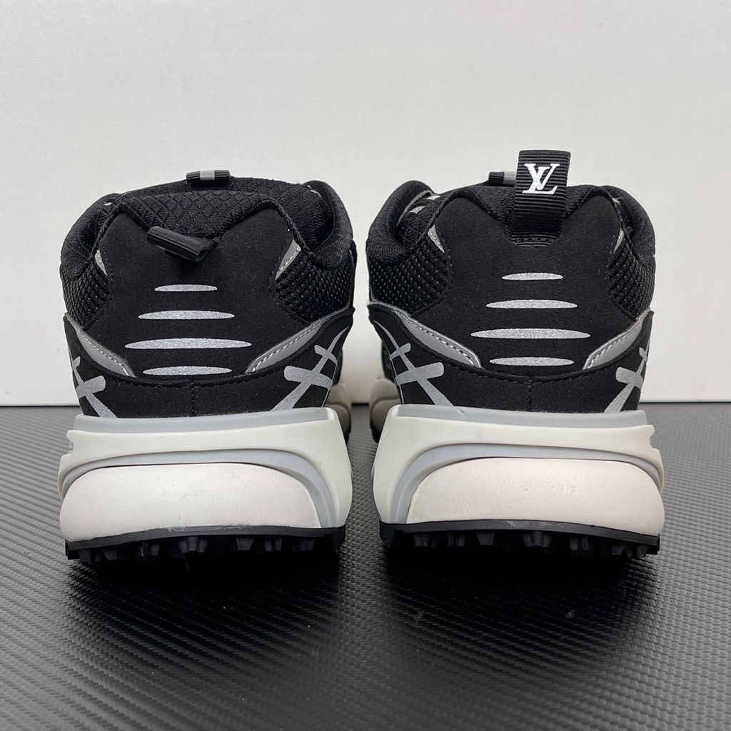 Louis Vuitton Tatic Runner lifestyle sneaker in black mesh and synthetic materials, featuring white and grey accents, prominent LV side logo, and "VUITTON" midsole embossing, SKU 1AKC07.