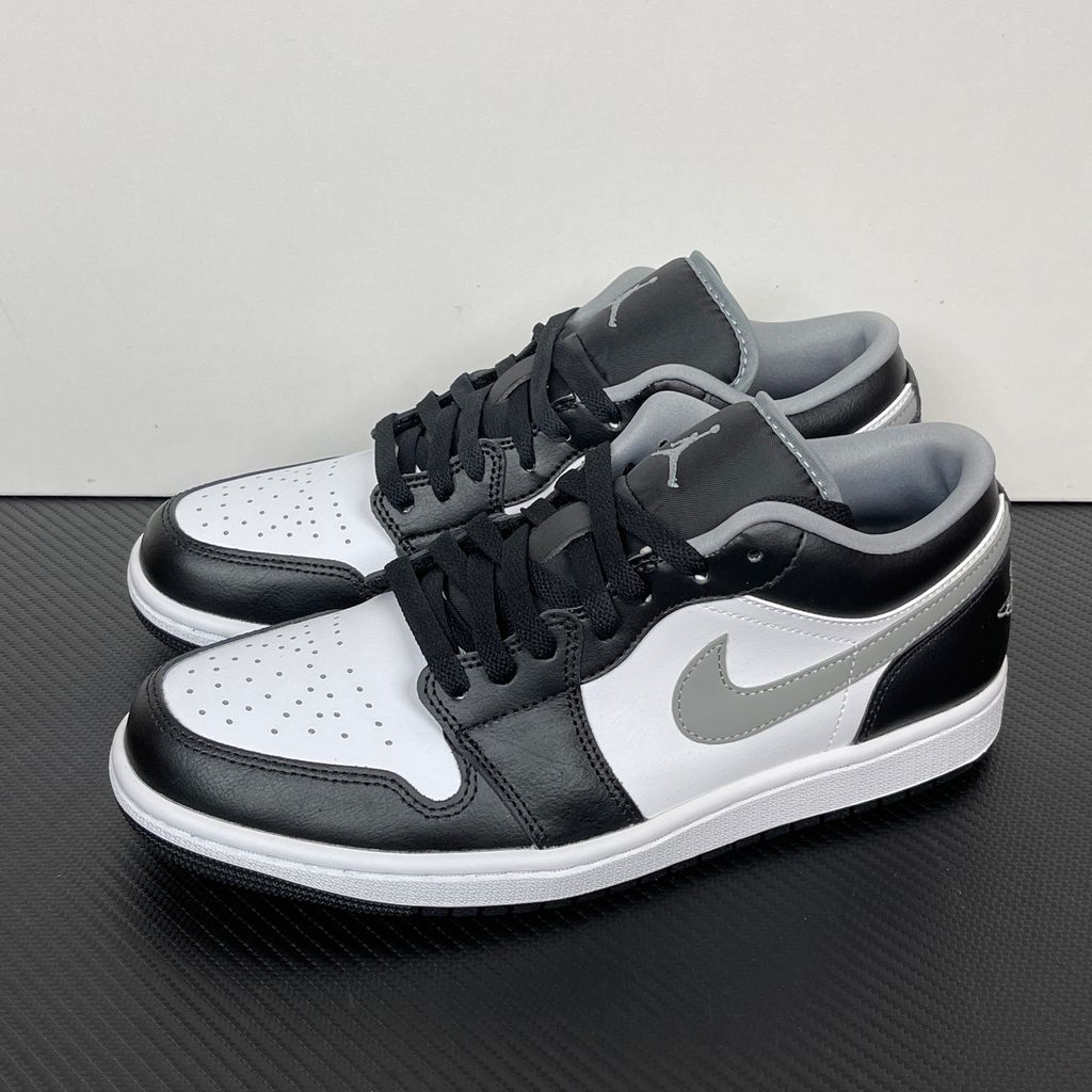 Air Jordan 1 Low lifestyle sneaker featuring a crisp white leather base, black leather overlays, and a neutral grey Swoosh and outsole, SKU 553558-040.