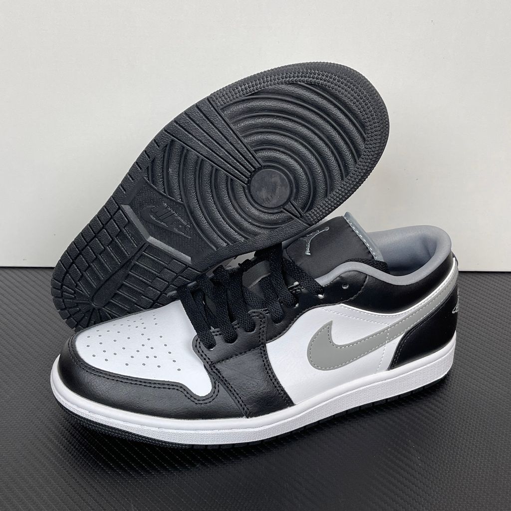 Air Jordan 1 Low lifestyle sneaker featuring a crisp white leather base, black leather overlays, and a neutral grey Swoosh and outsole, SKU 553558-040.