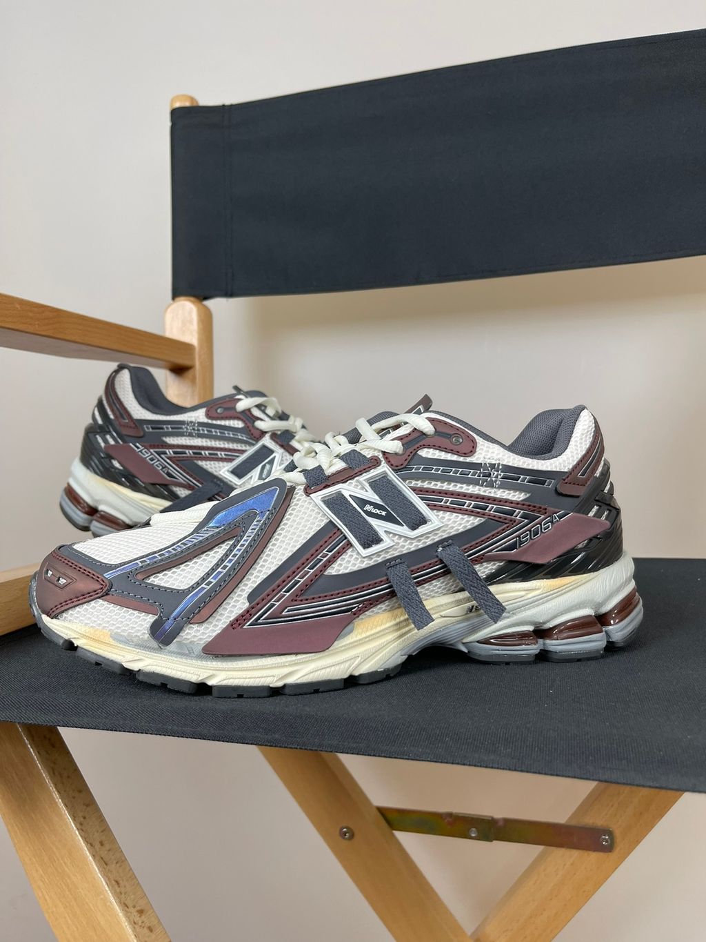 New Balance 1906A tech-runner in a deep "Eggplant" purple colorway, featuring a deconstructed layered mesh and synthetic upper, metallic details, and an ABZORB midsole, SKU U1906ANA.