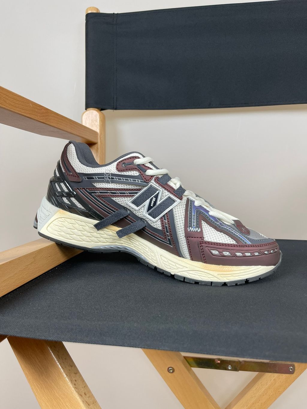 New Balance 1906A tech-runner in a deep "Eggplant" purple colorway, featuring a deconstructed layered mesh and synthetic upper, metallic details, and an ABZORB midsole, SKU U1906ANA.