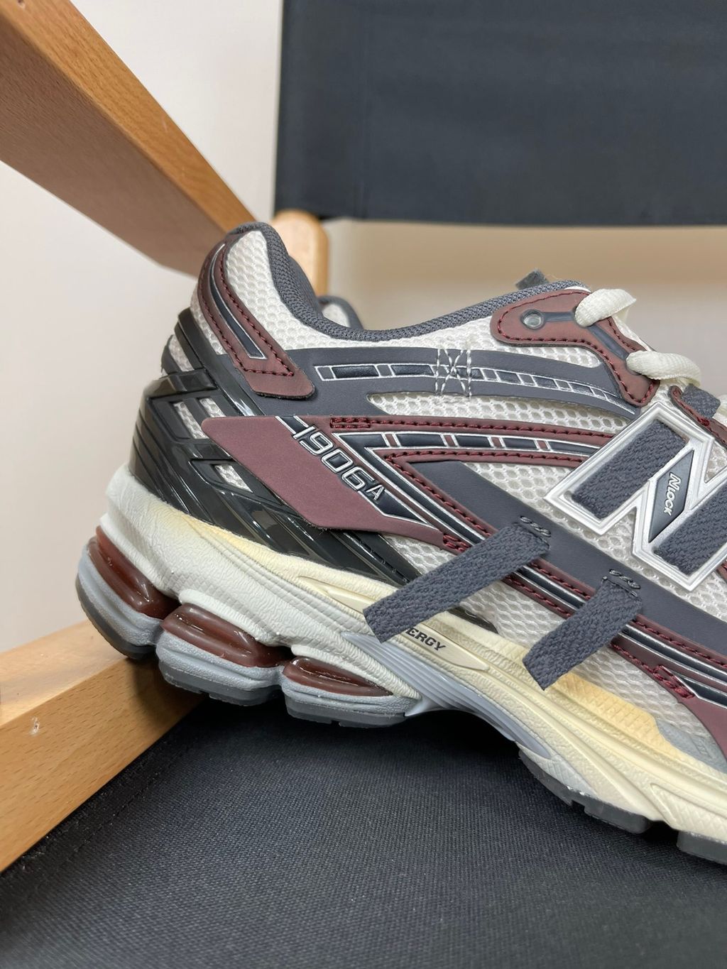 New Balance 1906A tech-runner in a deep "Eggplant" purple colorway, featuring a deconstructed layered mesh and synthetic upper, metallic details, and an ABZORB midsole, SKU U1906ANA.