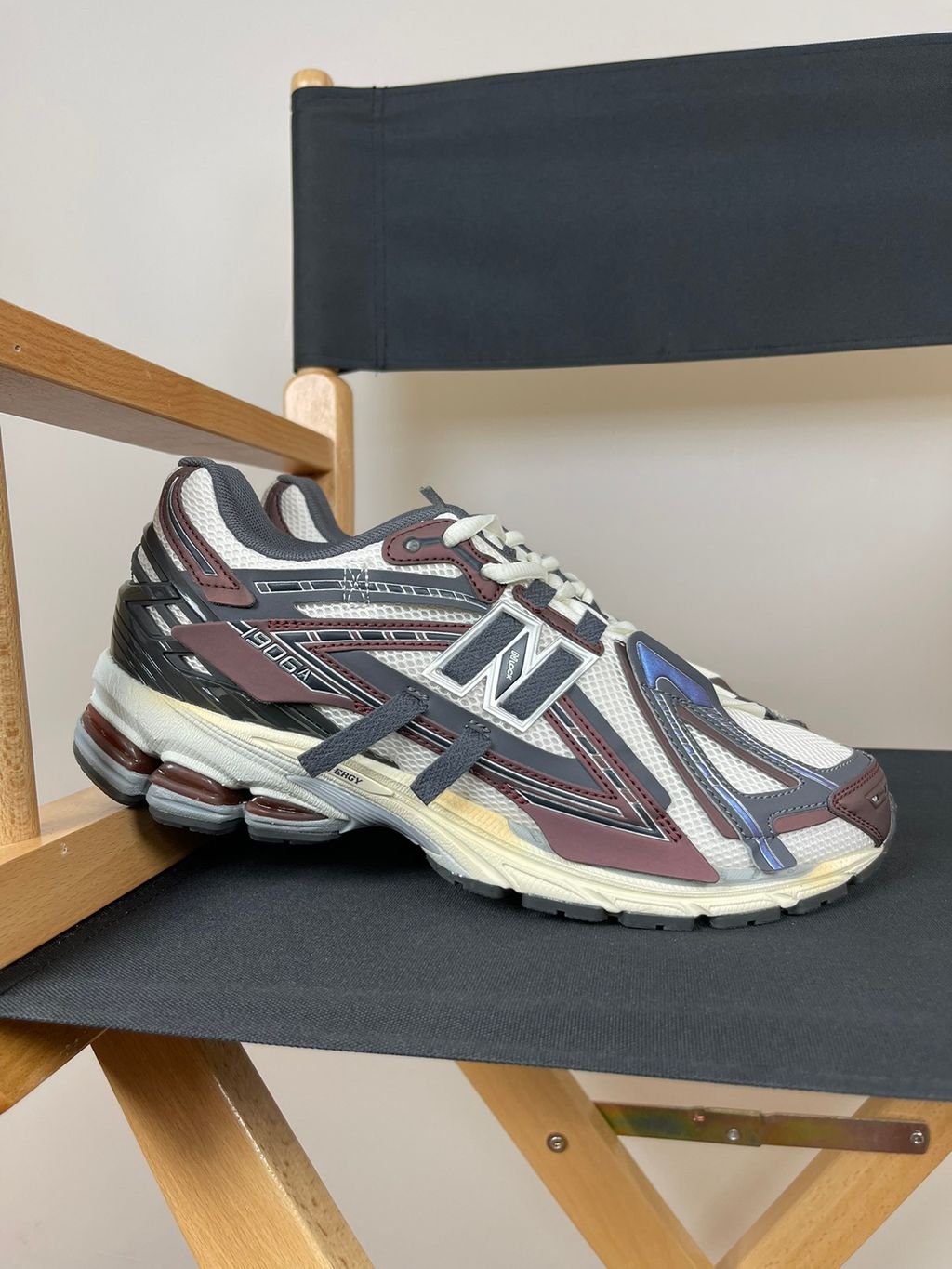 New Balance 1906A tech-runner in a deep "Eggplant" purple colorway, featuring a deconstructed layered mesh and synthetic upper, metallic details, and an ABZORB midsole, SKU U1906ANA.