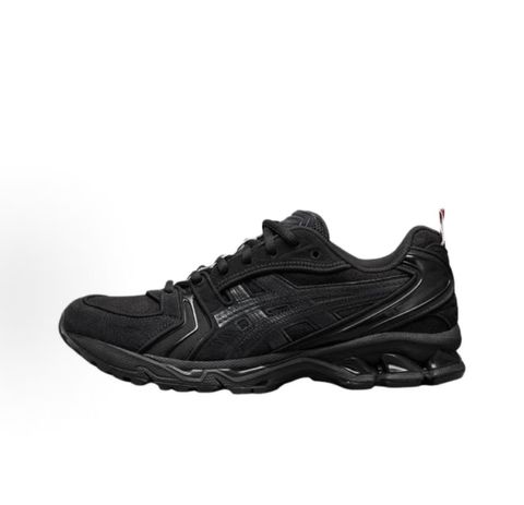 ASICS Gel-Kayano 14 x Thom Browne luxury performance sneaker in a monochromatic black colorway, featuring premium leather and mesh construction, co-branded detailing, and metallic accents, SKU 1203B110-001.