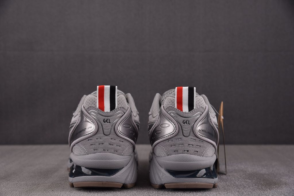 ASICS Gel-Kayano 14 x Thom Browne luxury performance sneaker in a monochromatic grey colorway, featuring premium leather and mesh construction, co-branded detailing, and metallic accents, SKU 1203B110-020.