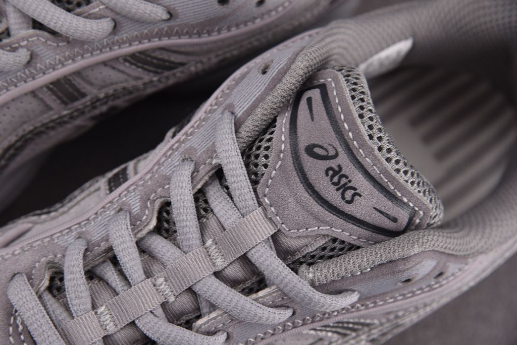 ASICS Gel-Kayano 14 x Thom Browne luxury performance sneaker in a monochromatic grey colorway, featuring premium leather and mesh construction, co-branded detailing, and metallic accents, SKU 1203B110-020.